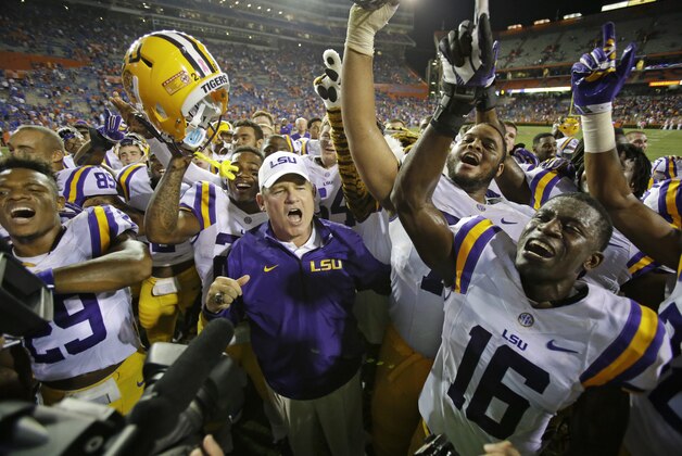LSU head coach Les Miles, center, celebrates with players including safety Rickey Jefferson (29) and defensive back Tre'Davious White (16) at an NCAA college football game in Gainesville, Fla., Saturday, Oct. 11, 2014. LSU won the game 30-27. (AP Photo/John Raoux)