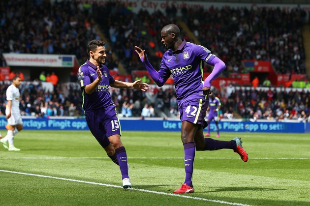 SWANSEA, WALES - MAY 17:  Yaya Toure of Manchester City is congratulated by teammate Jesus Navas of Manchester City after scoring his team's third goal during the Barclays Premier League match between Swansea and Manchester City at the Liberty Stadium on May 17, 2015 in Swansea, Wales.  (Photo by Michael Steele/Getty Images)