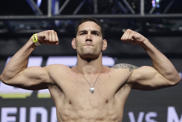 Chris Weidman poses on the scale during a weigh-in for the UFC 175 mixed martial arts event at the Mandalay Bay, Friday, July 4, 2014, in Las Vegas. Weidman is scheduled to fight Lyoto Machida in a middleweight title bout on Saturday in Las Vegas. (AP Photo/John Locher)
