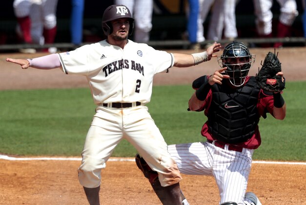 Texas A&M’s Ryne Birk (2) looks for the safe call from umpire Tony Maners after he slides into home plate under the tag of Alabama’s Will Haynie (24) during the third inning of a game at the Southeastern Conference college baseball tournament at the Hoover Met, Wednesday, May 20, 2015, in Hoover, Ala. Birk was safe.  (AP Photo/Butch Dill)