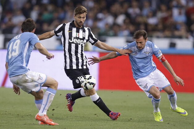 Juventus' Fernando Torres Llorente, center, tries to dribble past Lazio's Senad Lulic, left, and Lazio's Stefan Radu during their Italian Cup soccer final match between Lazio and Juventus at Rome's Olympic stadium, Wednesday, May 20, 2015. (AP Photo/Gregorio Borgia)