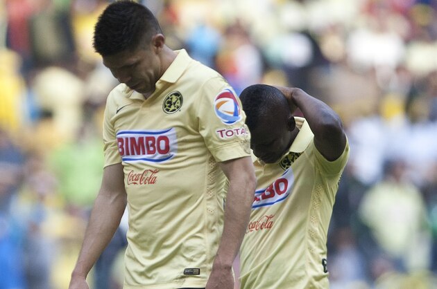 America's Oribe Peralta, left, and Carlos Quintero walk with their heads down after losing a Mexican soccer league match to Pachuca in Mexico City, Saturday, May 16, 2015. (AP Photo/Christian Palma)