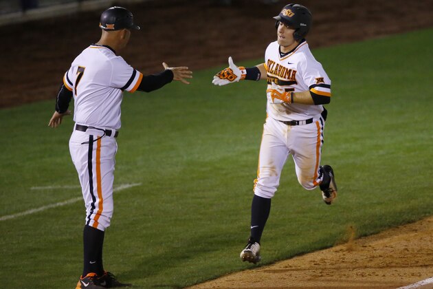 Oklahoma State's Donnie Walton, right, is congratulated by assistant coach Marty Lees after hitting a home run in the eighth inning of a first-round game against West Virginia at the NCAA college Big 12 conference baseball tournament in Tulsa, Okla., Wednesday, May 20, 2015. Oklahoma State won 3-0. (AP Photo/Sue Ogrocki)