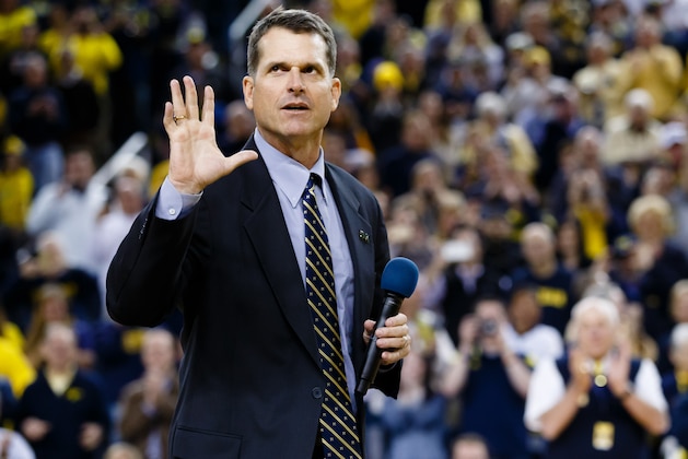 Dec 30, 2014; Ann Arbor, MI, USA; Michigan Wolverines head football coach Jim Harbaugh address the crowd during halftime of the basketball game against the Illinois Fighting Illini at Crisler Center. Mandatory Credit: Rick Osentoski-USA TODAY Sports