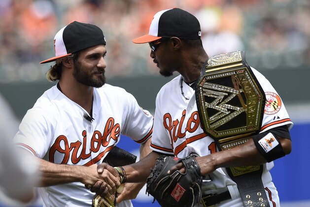 WWE world heavyweight champion Seth Rollins, left, shakes hands with Adam Jones after throwing out the ceremonial first pitch before the Baltimore Orioles and Los Angeles Angels baseball game Sunday, May 17, 2015 in Baltimore. (AP Photo/Gail Burton)