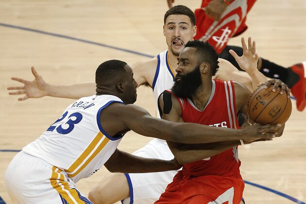 Houston Rockets guard James Harden, right, is defended by Golden State Warriors forward Draymond Green (23) and guard Klay Thompson during the second half of Game 2 of the NBA basketball Western Conference finals in Oakland, Calif., Thursday, May 21, 2015. The Warriors won 99-98. (AP Photo/Tony Avelar)