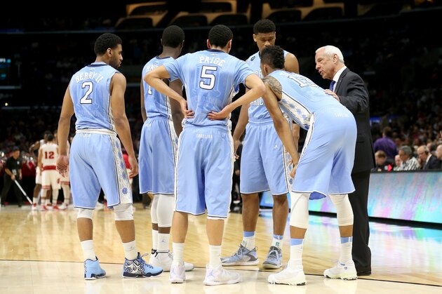 LOS ANGELES, CA - MARCH 26:  Head coach Roy Williams of the North Carolina Tar Heels huddles with his team during a break against the Wisconsin Badgers during the West Regional Semifinal of the 2015 NCAA Men's Basketball Tournament at Staples Center on March 26, 2015 in Los Angeles, California.  (Photo by Stephen Dunn/Getty Images)