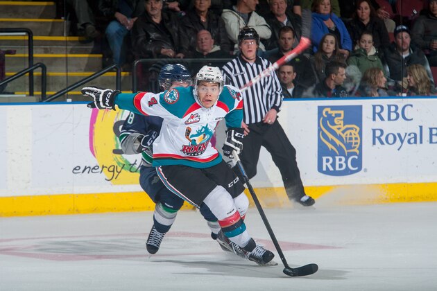 KELOWNA, CANADA - JANUARY 16: Madison Bowey #4 of Kelowna Rockets skates with the puck ahead of Scott Eansor #8 of Seattle Thunderbirds during third period on January 16, 2015 at Prospera Place in Kelowna, British Columbia, Canada.  (Photo by Marissa Baecker/Getty Images)