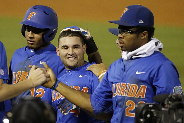 Florida's Richie Martin, far left, Mike Rivera, center and Buddy Reed, right, celebrate after Rivera drove in the final run during a seventh inning mercy rule of a Southeastern Conference college baseball tournament game against Arkansas at the Hoover Met, Friday, May 22, 2015, in Hoover, Ala. Florida won 10-0 in the seventh inning. (AP Photo/Brynn Anderson)