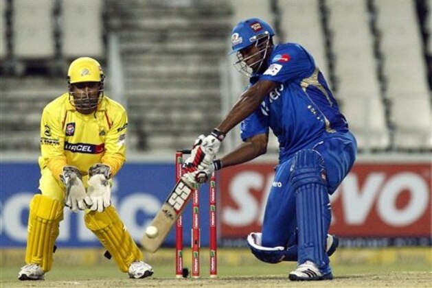 Mumbai Indians batsman Kieron Pollard, right, plays a shot as Chennai Supper Kings's captain MS Dhoni, left, looks on during their Champions League Twenty20 cricket match at the Wanderers Stadium in Johannesburg, South Africa, Saturday, Oct. 20, 2012. (AP Photo/ Themba Hadebe)