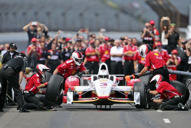 The crew of Helio Castroneves, of Brazil, performs his winning pit stop during the pit stop competition on he final day of practice before the Indianapolis 500 auto race at Indianapolis Motor Speedway in Indianapolis, Friday, May 22, 2015.  (AP Photo/AJ Mast)