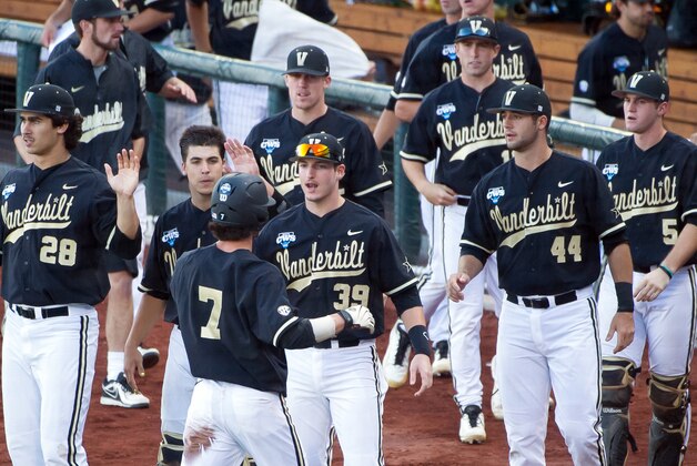 Jun 25, 2014; Omaha, NE, USA; Teammates congratulate Vanderbilt Commodores infielder Dansby Swanson (7) after scoring the first run of the game in the first inning during game three of the College World Series Finals against the Virginia Cavaliers at TD Ameritrade Park Omaha. Mandatory Credit: Steven Branscombe-USA TODAY Sports