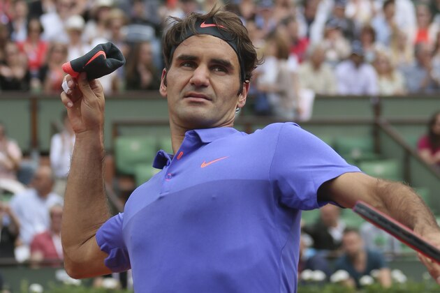 Switzerland's Roger Federer throws his sweat band to cheering fans after the first round match of the French Open tennis tournament against Colombia's Alejandro Falla at the Roland Garros stadium, in Paris, France, Sunday, May 24, 2015. Federer won in three sets 6-3, 6-3. 6-4. (AP Photo/David Vincent)