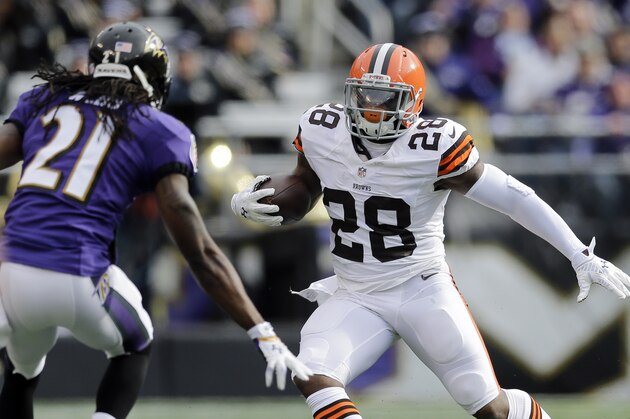 Cleveland Browns running back Terrance West, right, rushes the ball against Baltimore Ravens cornerback Lardarius Webb in the first half of an NFL football game, Sunday, Dec. 28, 2014, in Baltimore. (AP Photo/Patrick Semansky)