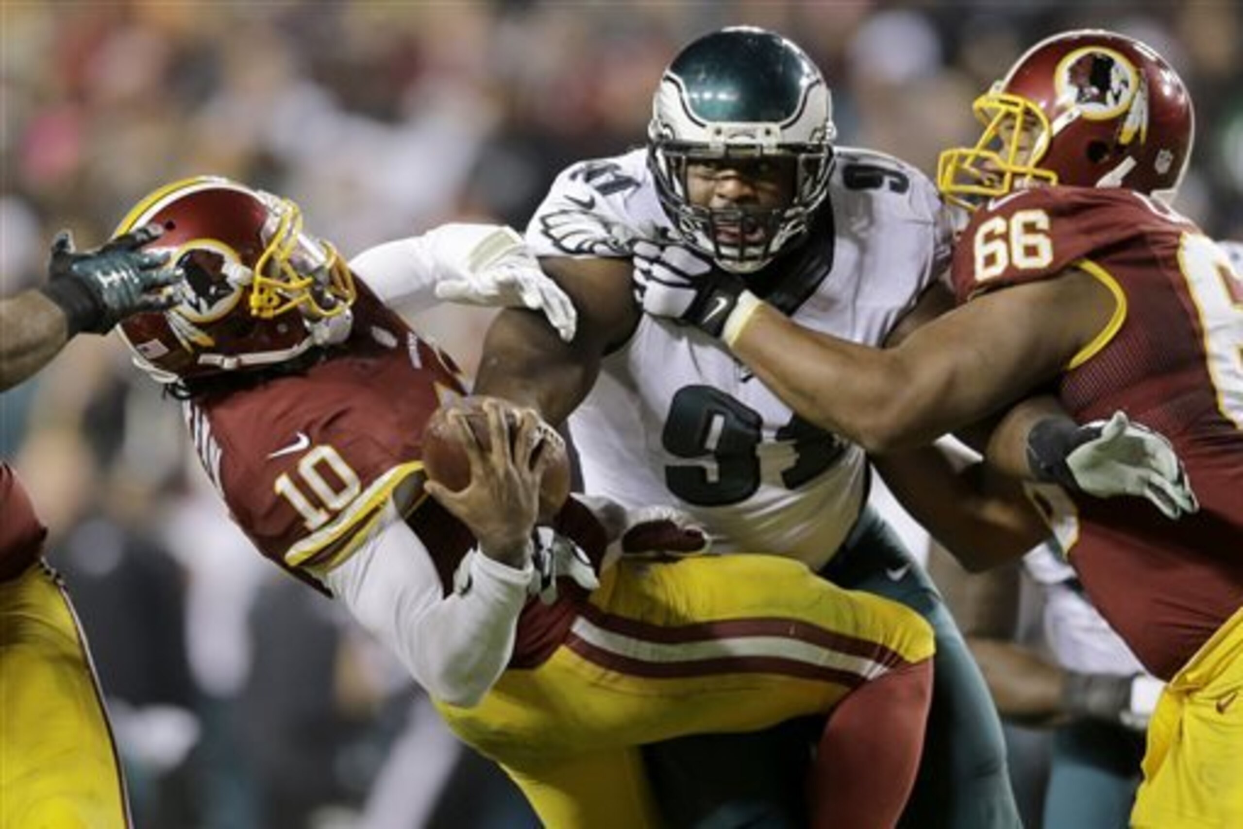 Washington Redskins quarterback Robert Griffin III (10) is sacked by Philadelphia Eagles defensive end Fletcher Cox (91) during the second half of an NFL football game in Landover, Md., Saturday, Dec. 20, 2014. (AP Photo/Patrick Semansky)