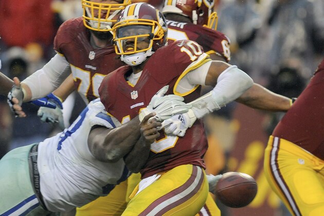 Washington Redskins quarterback Robert Griffin III (10) is sacked by Dallas Cowboys defensive tackle Terrell McClain and fumbles the ball, resulting in a turnover touchdown by Cowboys defensive end Anthony Spencer, during the second half of an NFL football game in Landover, Md., Sunday, Dec. 28, 2014. The Cowboys won 44-17. (AP Photo/Richard Lipski)