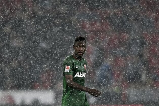 Augsburg's Abdul Rahman Baba from Ghana leaves the pitch after the match was interrupted because of heavy rain and lightning, during the German Bundesliga soccer match between Bayer Leverkusen and FC Augsburg in Leverkusen  Germany, Wednesday, Sept. 24, 2014. (AP Photo/Martin Meissner)