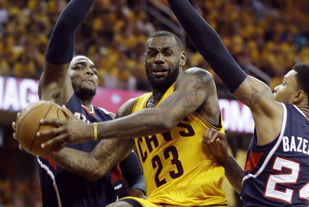 Cleveland Cavaliers' LeBron James (23) drives between Atlanta Hawks' Paul Millsap and Kent Bazemore (24) during the second half in Game 3 of the Eastern Conference finals of the NBA basketball playoffs Sunday, May 24, 2015, in Cleveland. (AP Photo/Tony Dejak)