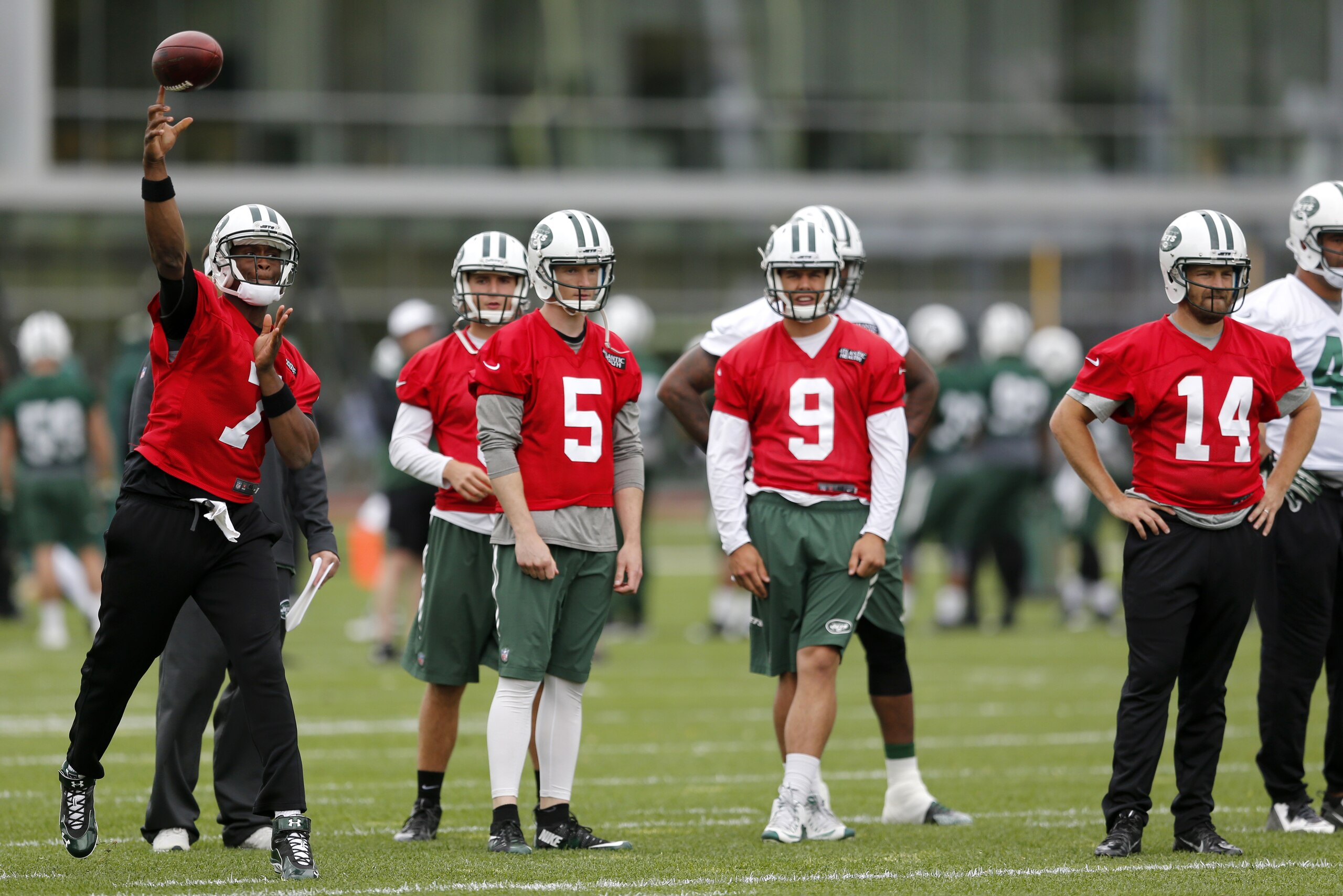 New York Jets quarterback Geno Smith (7) throws as quarterbacks Matt Simms (5), Bryce Petty (9), and Ryan Fitzpatrick (14) look on during an NFL football organized team activity, Wednesday, May 20, 2015, in Florham Park, N.J. (AP Photo/Julio Cortez)