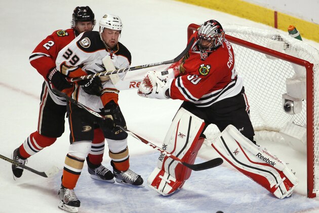Chicago Blackhawks goalie Corey Crawford (50) hits Anaheim Ducks' Matt Beleskey (39) with his stick, as defenseman Duncan Keith (2) watches as the puck approaches the goal during the third period in Game 4 of the Western Conference finals of the NHL hockey Stanley Cup playoffs, Saturday, May 23, 2015, in Chicago. (AP Photo/Charles Rex Arbogast)