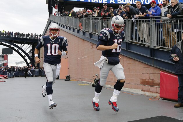 New England Patriots quarterbacks Jimmy Garoppolo (10) and Tom Brady (12) run onto the field for warms-up's before an NFL football game against the Buffalo Bills Sunday, Dec. 28, 2014, in Foxborough, Mass. (AP Photo/Elise Amendola)