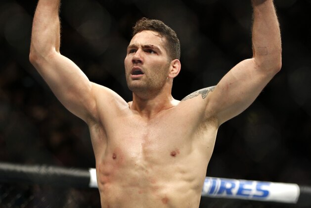 Chris Weidman celebrates after defeating Vitor Belfort in their middleweight mixed martial arts bout at UFC 187 Saturday, May 23, 2015, in Las Vegas. (AP Photo/John Locher)