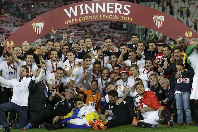 Sevilla players celebrate with the Europa League trophy after wining the Europa League soccer final between Sevilla and Benfica, at the Turin Juventus stadium, in Turin, Italy, Wednesday, May 14, 2014. (AP Photo/Andrew Medichini)