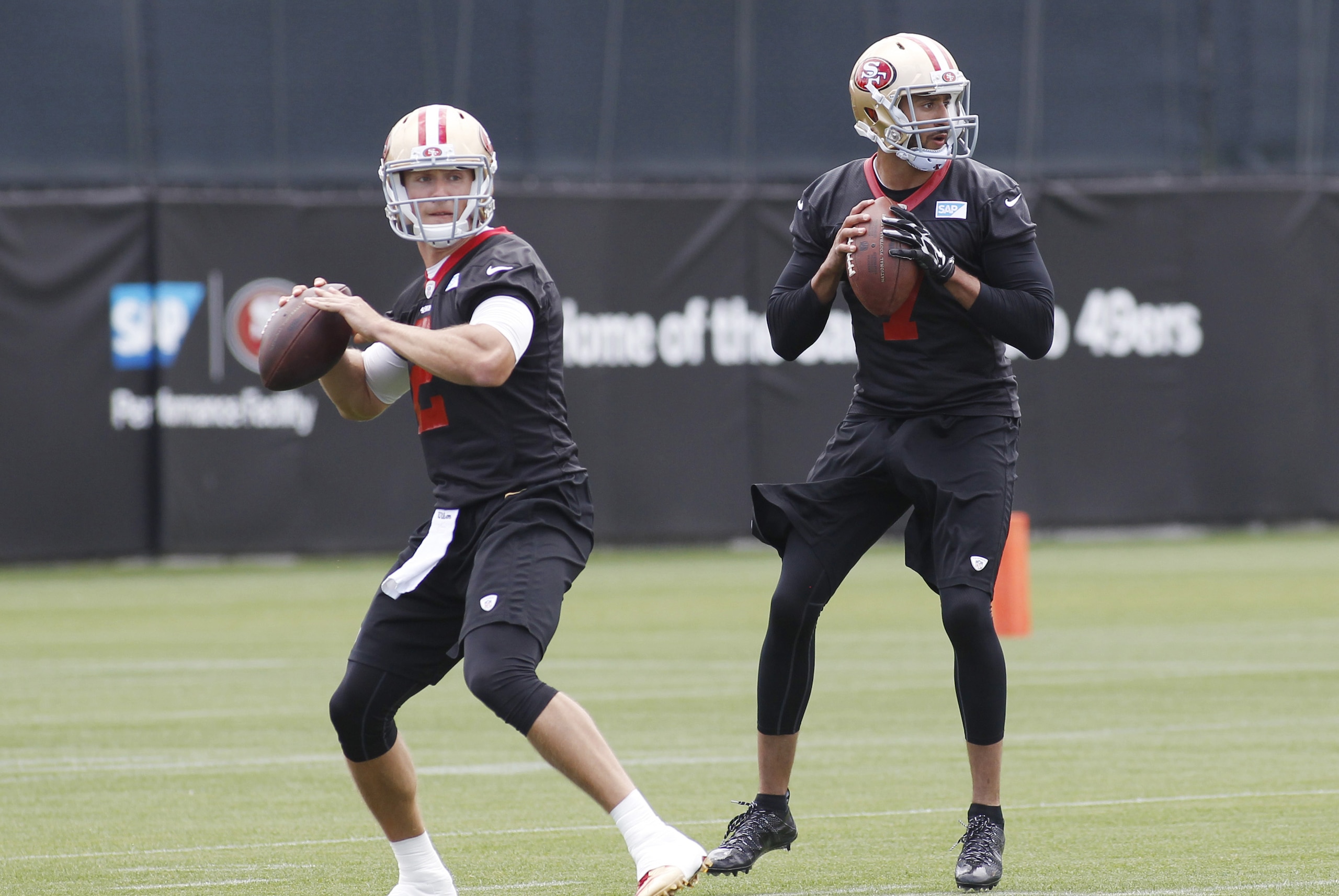 San Francisco 49ers quarterbacks Blaine Gabbert, left, and Colin Kaepernick look to pass during NFL football practice, Thursday, May 21, 2015, in Santa Clara, Calif. (AP Photo/George Nikitin)