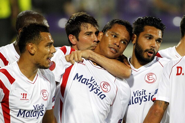 Sevilla's  Carlos Bacca, center, celebrates with teammates after scoring during an  Europa League semifinal, return match, between Fiorentina and Seville, at the Artemio Franchi stadium in Florence, Italy, Thursday, May 14, 2015.  (AP Photo/Fabrizio Giovannozzi)