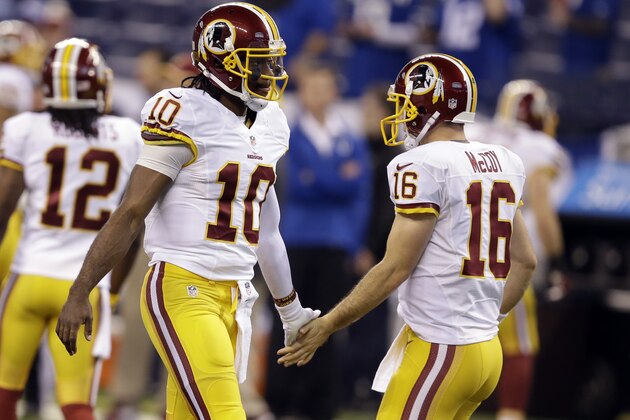 Washington Redskins quarterback Robert Griffin III, left, greets starting quarterback Colt McCoy before an NFL football game against the Indianapolis Colts in Indianapolis, Sunday, Nov. 30, 2014. (AP Photo/Darron Cummings)