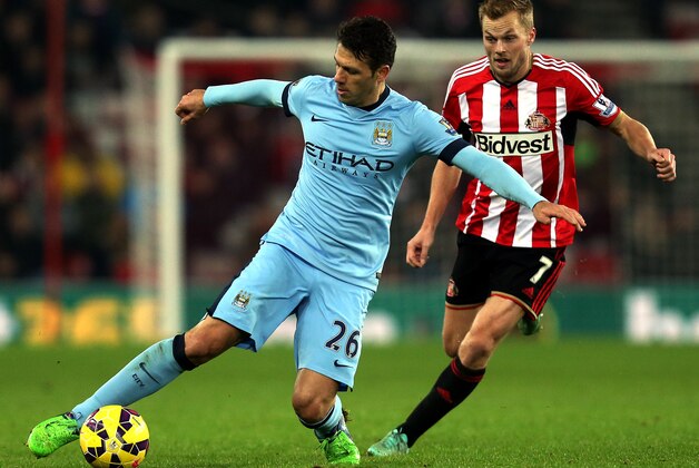 Manchester City's Martin Demichelis, left, vies for the ball with Sunderland's Seb Larsson, right, during their English Premier League soccer match at the Stadium of Light, Sunderland, England, Wednesday, Dec. 3, 2014. (AP Photo/Scott Heppell)