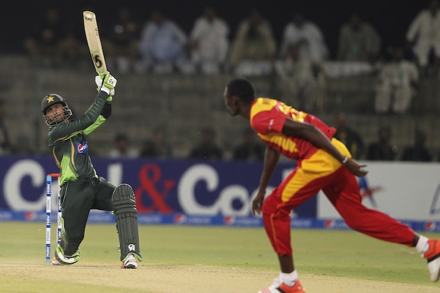 Pakistan's Shoaib Malik hits boundary as Zimbabwe's Christopher Mpofu looks on during a one-day international match at the Gaddafi Stadium in Lahore, Pakistan, Tuesday, May 26, 2015. Malik made an impressive return to limited-overs cricket with a blistering century on Tuesday, propelling Pakistan to 375-3 in the first one-day international against Zimbabwe. (AP Photo/K.M. Chaudary)