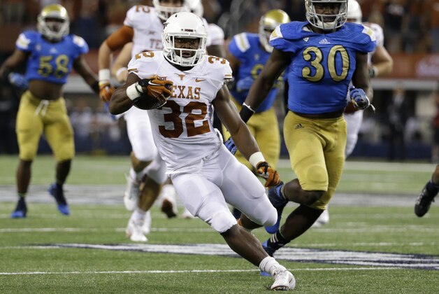 Texas running back Johnathan Gray (32) finds running room as UCLA linebacker Myles Jack (30) gives chase during an NCAA college football game, Saturday, Sept. 13, 2014, in Arlington, Texas. (AP Photo/Tony Gutierrez)