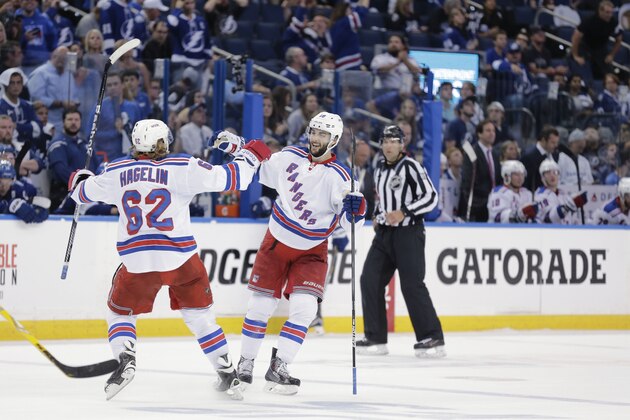 New York Rangers left wing Carl Hagelin, of Sweden, congratulates center Derick Brassard (16) on his third period empty net goal in Game 6 of the Eastern Conference finals against the Tampa Bay Lightning, during an NHL hockey Stanley Cup playoffs game,Tuesday, May 26, 2015, in Tampa, Fla. The Rangers defeated the Lightning 7-3. (AP Photo/Chris O'Meara)