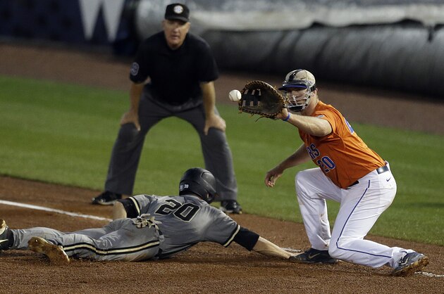 Vanderbilt’s Bryan Reynolds (20) beats the throw back to Florida's first baseman Peter Alonso during the fourth inning of the Southeastern Conference NCAA college baseball tournament championship game at the Hoover Met, Sunday, May 24, 2015, in Hoover, Ala. (AP Photo/Butch Dill)
