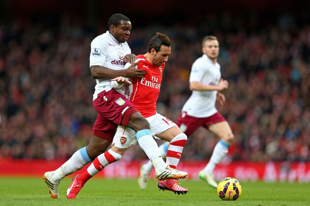 LONDON, ENGLAND - FEBRUARY 01:  Santi Cazorla of Arsenal holds off the challenge from Jores Okore of Aston Villa during the Barclays Premier League match between Arsenal and Aston Villa at the Emirates Stadium on February 1, 2015 in London, England.  (Photo by Clive Mason/Getty Images)