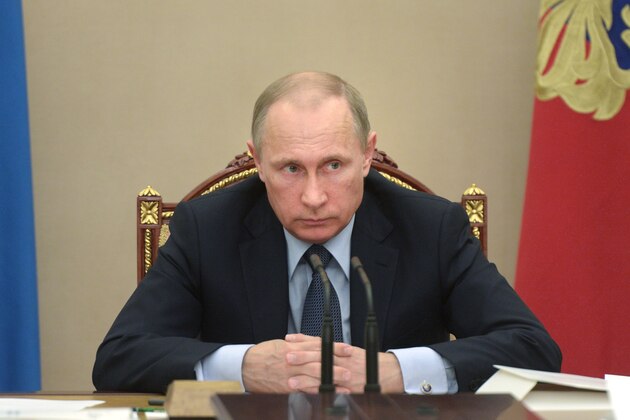 In this Wednesday, May 27, 2015 pool photo Russian President Vladimir Putin listens during a meeting in the Kremlin, Moscow, Russia. Putin says the United States is meddling in FIFA's affairs in an attempt to take the 2018 World Cup away from his country. Putin said in televised comments Thursday, May 28, 2015, that it is