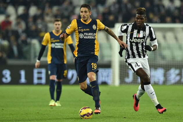 TURIN, ITALY - JANUARY 18:  Leandro Greco (L) of Hellas Verona FC in action against Paul Pogba (R) of Juventus FC during the Serie A match between Juventus FC and Hellas Verona FC at Juventus Arena on January 18, 2015 in Turin, Italy.  (Photo by Valerio Pennicino/Getty Images)
