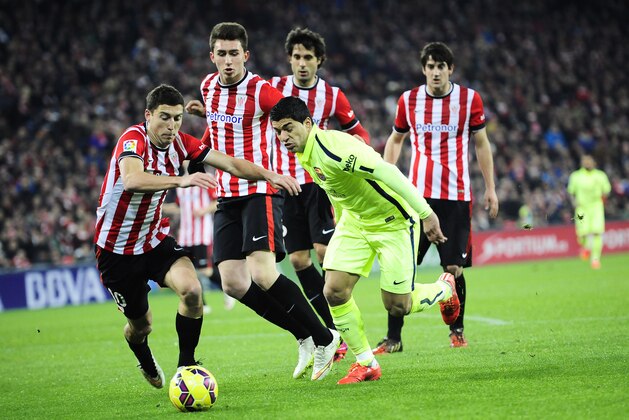 Barcelona's Luis Suarez of Uruguay, right, duels for the ball during their La Liga soccer match between Athletic Bilbao and FC Barcelona, at San Mames stadium in Bilbao, northern Spain, Sunday, Feb. 8, 2015. (AP Photo/Alvaro Barrientos)
