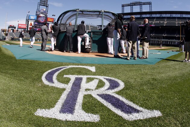 The logo of the Colorado Rockies is painted on the field behind home plate at Coors Field as members of the San Diego Padres and Colorado Rockies prepare for the Rockies' home-opening home baseball game in Denver on Friday, April 9, 2010. (AP Photo/David Zalubowski)