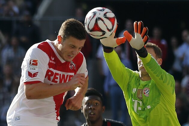 Cologne's Kevin Wimmer from Austria, left, and Bayern's goalkeeper Manuel Neuer challenge for the ball during the German first division Bundesliga soccer match between FC Cologne and Bayern Munich in Cologne, Germany, Saturday, Sept. 27, 2014. (AP Photo/Frank Augstein)