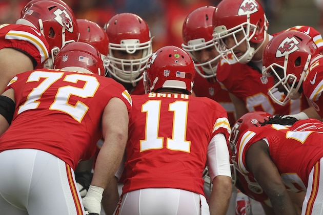 Kansas City Chiefs players huddle around Kansas City Chiefs quarterback Alex Smith (11) during the first half of an NFL football game in Kansas City, Mo., Sunday, Dec. 14, 2014. (AP Photo/Ed Zurga)