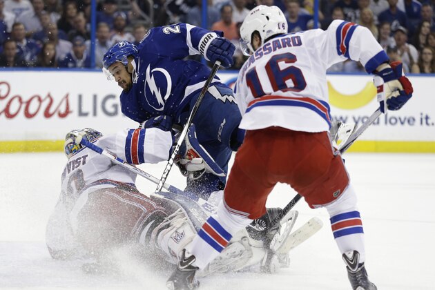Tampa Bay Lightning right wing J.T. Brown (23) collides with New York Rangers goalie Henrik Lundqvist (30), of Sweden, during the second period of Game 6 of the Eastern Conference finals in the NHL hockey Stanley Cup playoffs, Tuesday, May 26, 2015, in Tampa, Fla. To the right is Rangers center Derick Brassard. (AP Photo/Chris O'Meara)