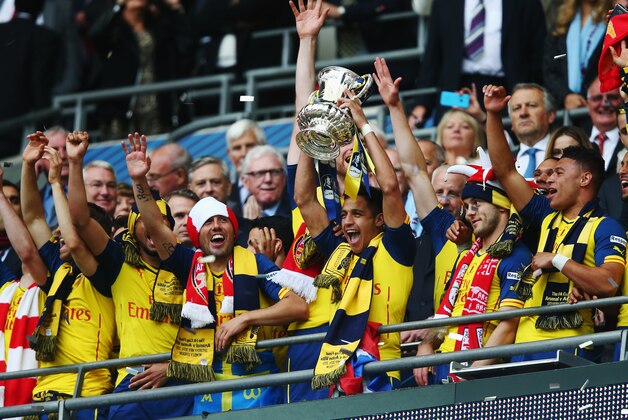 LONDON, ENGLAND - MAY 30:  Alexis Sanchez of Arsenal lifts the trophy in celebration after the FA Cup Final between Aston Villa and Arsenal at Wembley Stadium on May 30, 2015 in London, England. Arsenal beat Aston Villa 4-0.  (Photo by Clive Rose/Getty Images)
