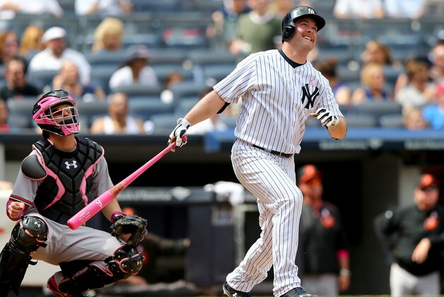 NEW YORK, NY - MAY 10:  Brian McCann #34 of the New York Yankees hits a solo home run as Caleb Joseph #36 of the Baltimore Orioles defends on May 10, 2015 at Yankee Stadium in the Bronx borough of New York City.Members of the New York Yankees and the Baltimore Orioles wear pink today in honor of Mother's Day.  (Photo by Elsa/Getty Images)
