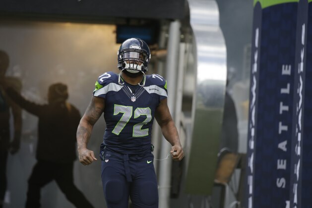 Seattle Seahawks defensive end Michael Bennett runs out of the tunnel before an NFL football game against the Arizona Cardinals, Sunday, Nov. 23, 2014, in Seattle. (AP Photo/Elaine Thompson)