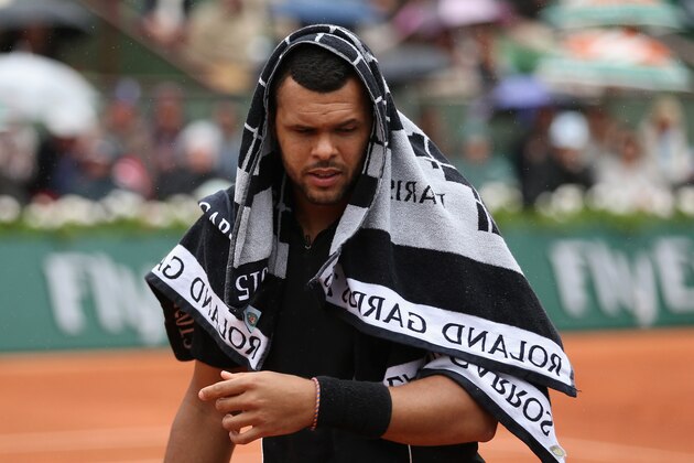 PARIS, FRANCE - MAY 31:  Jo-Wilfried Tsonga of France uses a towel to shelter from the rain in his Men's Singles match against Tomas Berdych of Czech Republic on day eight of the 2015 French Open at Roland Garros on May 31, 2015 in Paris, France.  (Photo by Clive Brunskill/Getty Images)
