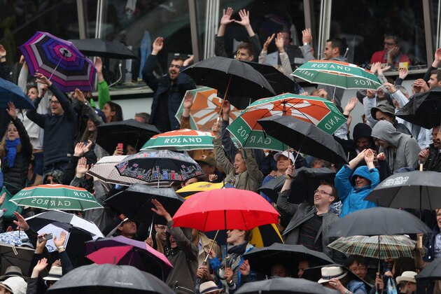 PARIS, FRANCE - MAY 31:  Spectators take part in a mexican wave as it rains during the Men's Singles match between Jo-Wilfried Tsonga and Tomas Berdych of Czech Republic on day eight of the 2015 French Open at Roland Garros on May 31, 2015 in Paris, France.  (Photo by Clive Brunskill/Getty Images)