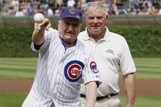 Former Chicago Cubs shortstop Lennie Merullo, left, throws out a ceremonial first pitch as his son Lennie Merullo Jr., looks on before a baseball game between the Miami Marlins and the Chicago Cubs in Chicago, Saturday, June 7, 2014. Lennie Merullo is the only living Cubs player to have played in a World Series. (AP Photo/Nam Y. Huh)