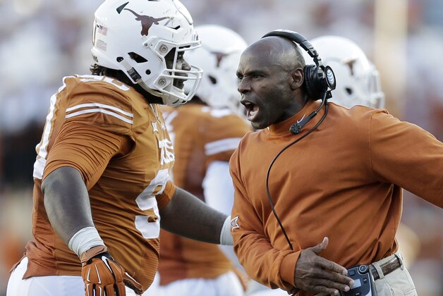 Texas Longhorns head coach Charlie Strong, right, celebrates with Malcom Brown, left, during the second half of an NCAA college football game against West Virginia, Saturday, Nov. 8, 2014, in Austin, Texas.  Texas won 33-16. (AP Photo/Eric Gay)